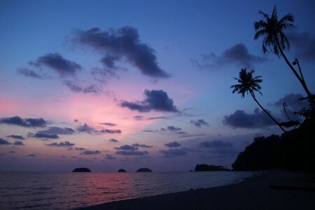 View at the sunset sky and sea with palms trees a beach. Koh Chang, Thailand.の写真素材