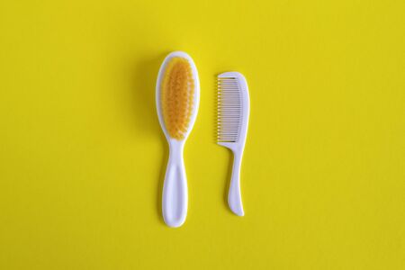 Hairbrush and comb for baby on white background, flat lay with copy space. Baby care concept.の写真素材