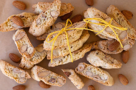 Flat lay on typical Italian sweet almond cookies - cantucci (cantuccini) or biscotti decorated yellow ribbon on craft paper.の写真素材