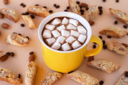 Cup with black coffee with marshmallows and cookies cantuccini, decorated almond and coffee beans on pink background.の写真素材
