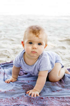 Little baby girl playing with sand at the beach. Sensory development for kids outdoors.の写真素材