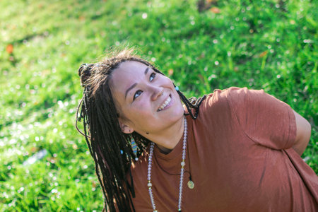 Portrait of beautiful European woman with long African braids. Woman is doing yoga exercise outside...