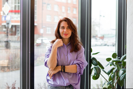 Portrait of an attractive young businesswoman standing with her arms folded in a cafe.