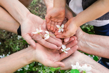 Family bonding is portrayed through holding hands with delicate flowers, symbolizing love and unity.の写真素材