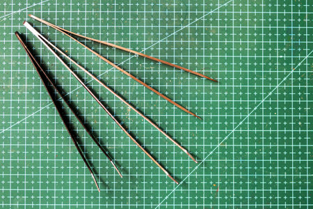 Top view on set of high-quality metal precision tweeters on a green background for craftsの写真素材