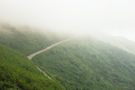 A Scenic Drive Along a Winding Road Through a Mountain Landscape Surrounded by Mist. Prao, Vietnam.の写真素材