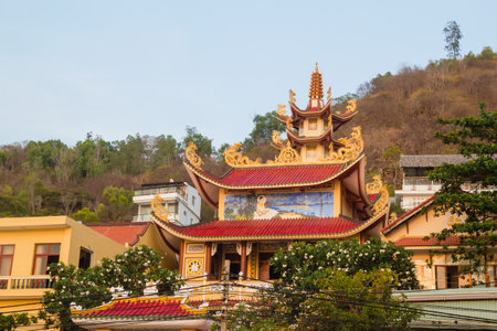 Traditional Buddhist temple in lush greenery, with architectural details and ornate carvings.の写真素材