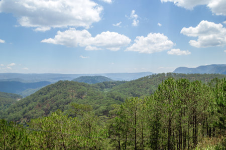 Lush Green Mountain Landscape Under Vibrant Blue Sky with Fluffy White Clouds View. Dalat, Vietnam.の写真素材