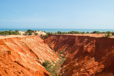 Stunning Red Sand Canyon Under a Clear Blue Sky. A Natural Wonder Landscape View. Mui Ne, Vietnam.の写真素材