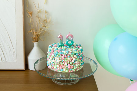 Celebratory 18th Birthday Cake with Colorful Balloons, Festive Decoration in a pastel colors.の写真素材