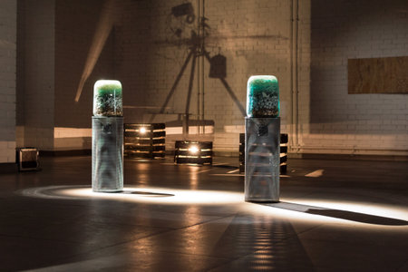Surreal Art Installation with Cylindrical Sculptures and Dramatic Lighting in Industrial Space.
