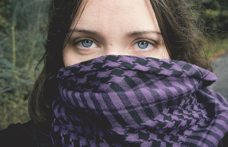 Chica de ojos azules con bufanda cubriendole la mitad de la caraの写真素材