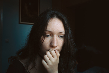 thoughtful girl with her hand on her lipsの写真素材