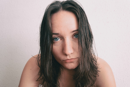 a girl with long hair and blue eyes looking at cameraの写真素材