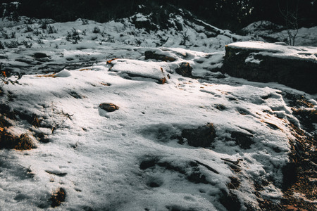 Semi-covered stones by snow in natureの写真素材