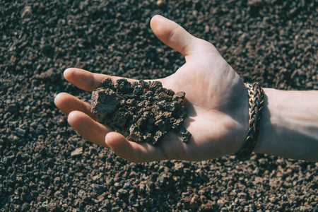 Close-up of a human hand holding some volcanic rocksの写真素材