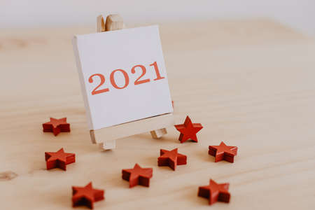 2021 written in brown on the canvas of an easel with dried brown fruits and flowers around it.の写真素材