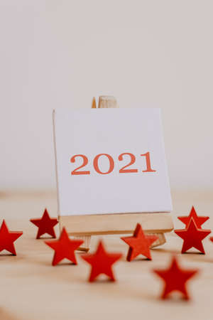 2021 written in brown on the canvas of an easel with dried brown fruits and flowers around it.の写真素材