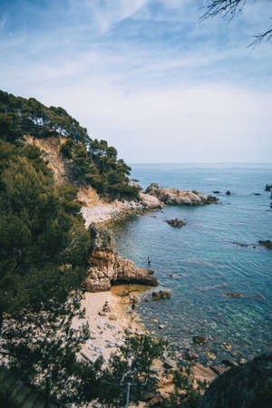 Landscape with views of two pebble coves with some bathers in the wildの写真素材
