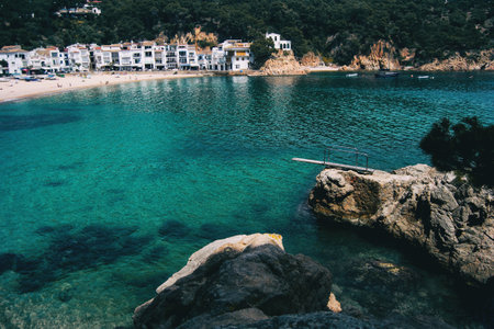 Beach in a town on the Costa Brava, Catalonia, Spain. the sea has crystal clear water and has a trampolineの写真素材