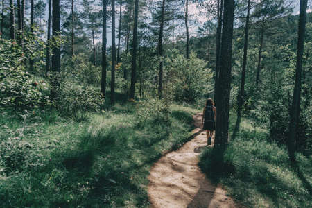 woman walking along a small path in the mountainの写真素材