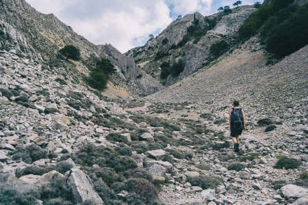 woman hiking on a mountain path in catalonia on a cloudy summer dayの写真素材