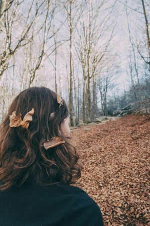 woman enjoying autumn and catching falling yellow leaves
