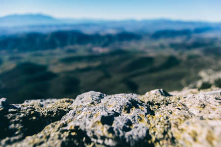 textured stone seen up close with a defocused mountains horizonの写真素材