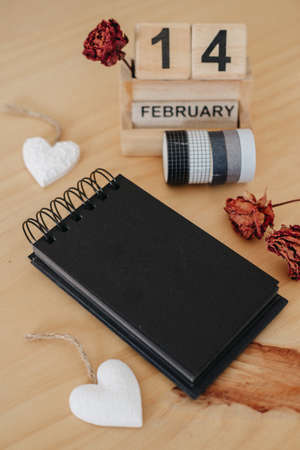 Wooden calendar on February 14 with roses and heart. happy valentines day conceptの写真素材