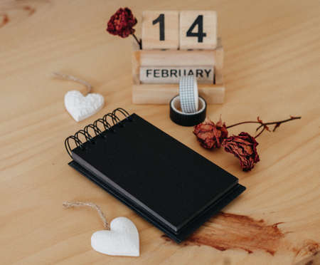 Wooden calendar on February 14 with roses and heart. happy valentines day conceptの写真素材