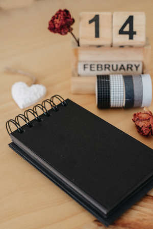 Wooden calendar on February 14 with roses and heart. happy valentines day conceptの写真素材