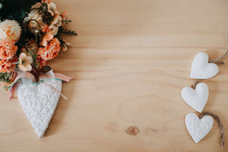 wooden table with a bouquet of flowers and a white heartの写真素材