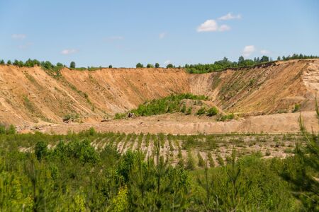 Landscape: inactive abandoned overgrown sand quarry under a blue skyの写真素材