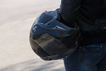 Biker girl: woman holds black motorcycle helmet in her handの写真素材