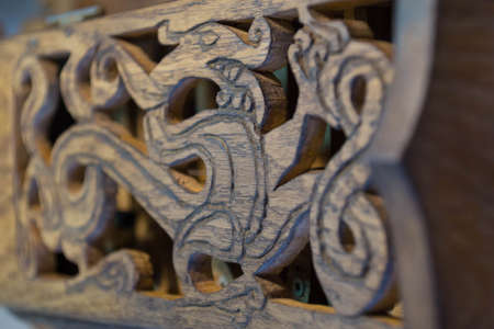 An image of a dragon carved from wood - an ancient Novgorod ornament - on the lid of a hand-made folk musical instrument hurdy-gurdyの写真素材