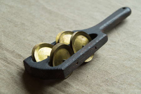 Black rhythm clapper (rumba, pandeiro) - a noise wooden percussion folk musical instrument consisting of a handle and a frame with eight metal cymbals fixed in pairsの写真素材