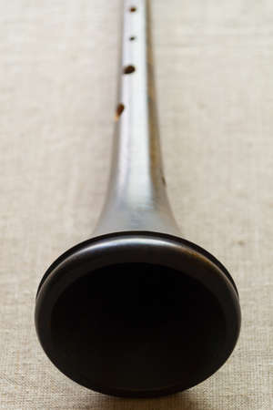 Trumpet of a medieval European woodwind musical instrument - shawm (schalmei, schalmeien) - close-up on a gray canvasの写真素材