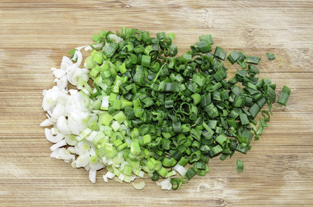 Chopped green onion on woode board. Top viewの写真素材