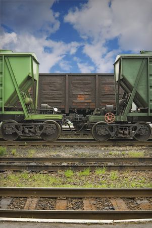 Cargo railway station. Three old railway cars for loose and common cargo are staying on the middle railways. There is a small summer rain.の写真素材