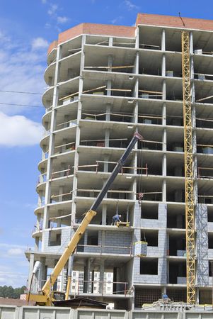 Building appartments, workers, machines. Blue and cloudy summer sky.の写真素材