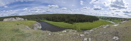 Small river flows between hills. The main object on shot is breakage with fields and wood. On the right side you can see small village. Shot was taken in june at 15:00.の写真素材