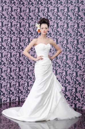 Full length portrait of the young adult bride with lily flowers in hairの写真素材
