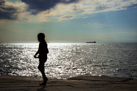 girl walking in front of the seaの写真素材