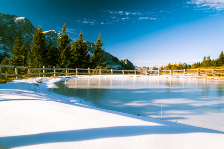 iced little lake in the italian alps in a sunny winter dayの写真素材
