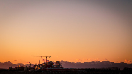 sunset on the highway in front of an industryの写真素材