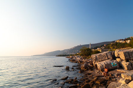 sunset at the beach below the lighthouse of Trieste, Friuli Venezia-Giulia, Italyの写真素材