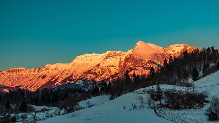 Sunset in the mountains between Slovenia and Italy in a freezing winter dayの写真素材