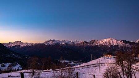 Sunset in the mountains between Slovenia and Italy in a freezing winter dayの写真素材