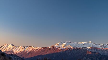 Sunset in the mountains between Slovenia and Italy in a freezing winter dayの写真素材