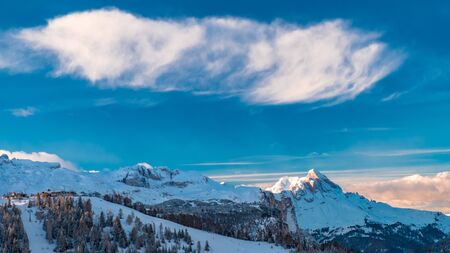 Sun goes down on an alpine valley in italy during a snowy winterの写真素材